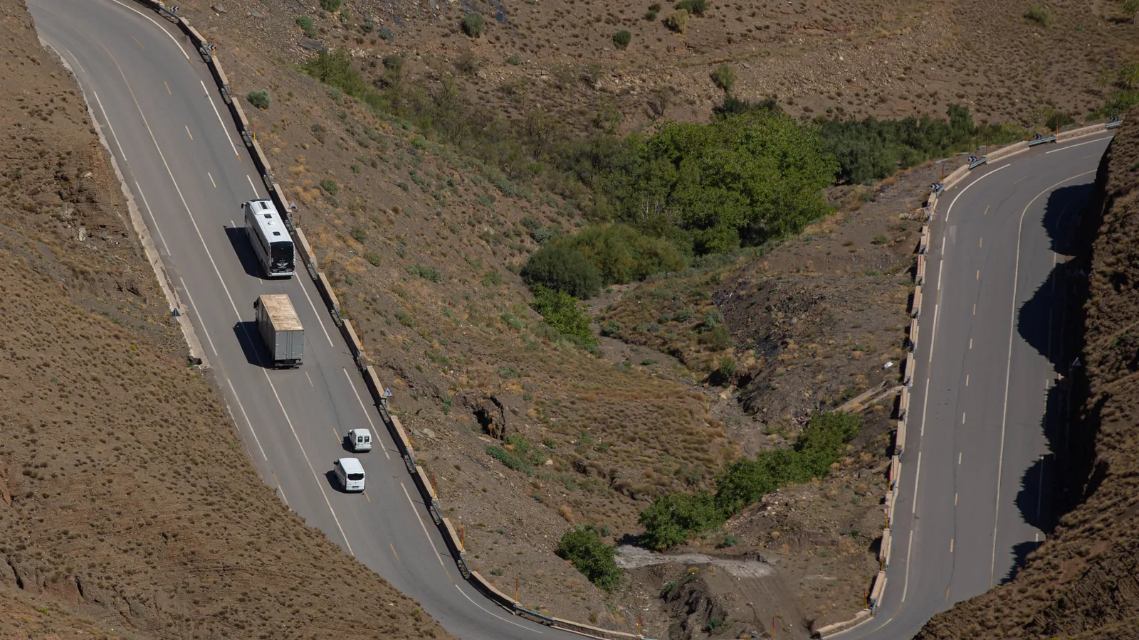 Lacets de la route du col du Tizi n'Tichka dans le Haut Atlas, avec un car, un camion et des voitures